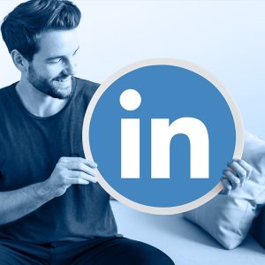 Un homme qui tient un logo Linkedin géant