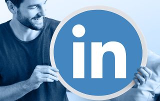 Un homme qui tient un logo Linkedin géant
