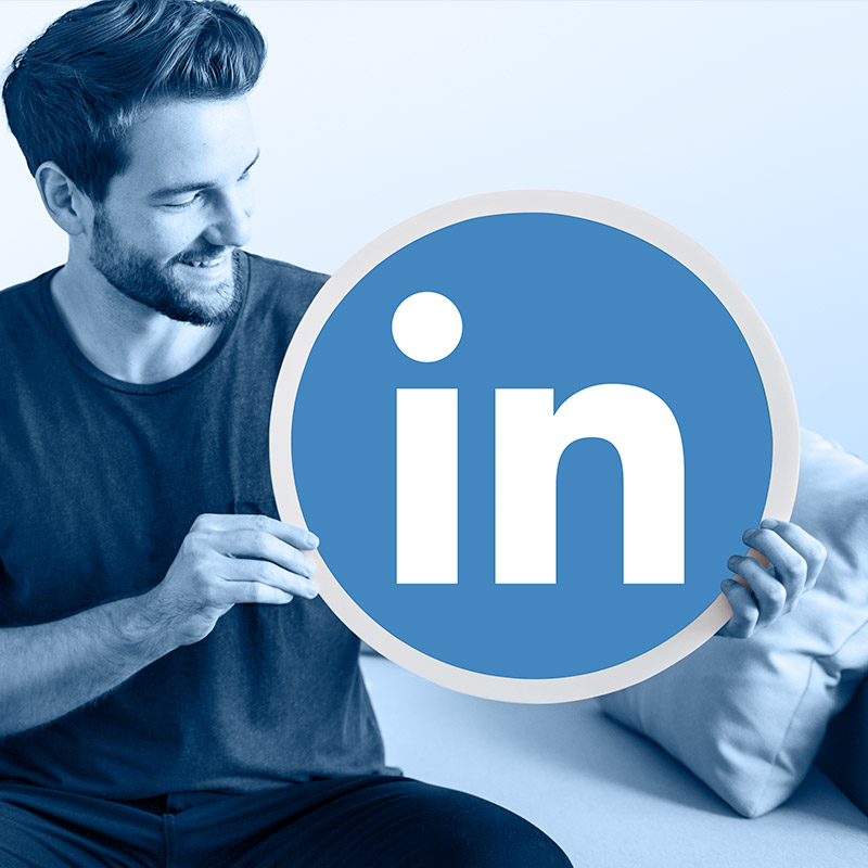 Un homme qui tient un logo Linkedin géant