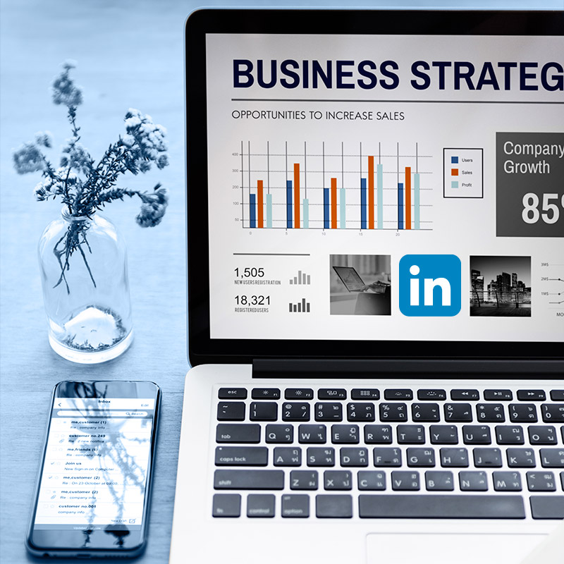 LinkedIn B2B industrie : le levier que vos concurrents utilisent déjà pour vous prendre des marchés Un bureau sur lequel se trouve un ordinateur portable, un smartphone et un petit bouquet. Sur l'écran de l'ordinateur il y a écrit "Business strategy" et il y a le logo LinkedIn.