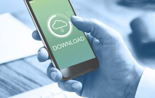 Un zoom sur un homme en train de télécharger un fichier sur son téléphone portable.