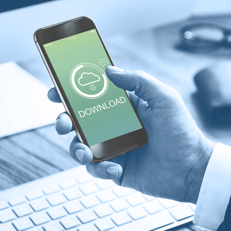 Un zoom sur un homme en train de télécharger un fichier sur son téléphone portable.