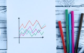 Un carnet à spirales sur lequel est représenté un graphique composé de plusieurs lignes colorées.